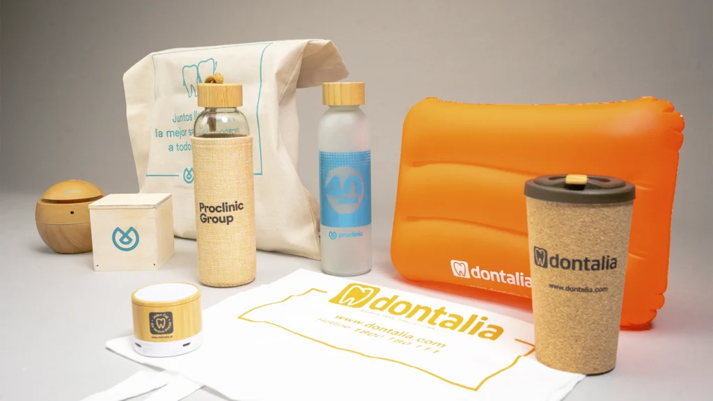 Botellas y producto promocional personalizado de una marca del sector dental sobre fondo neutro