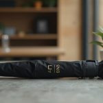 merchandising para empresas con varias sedes: paraguas plegable negro mate con marcaje en oro sobre hormigón